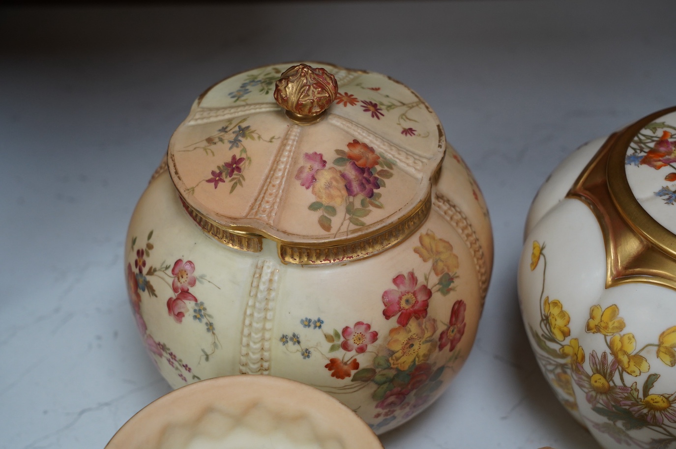 Two Worcester blush ivory biscuit jars and covers, numbers 1412 and 1796, a shell dish, number 971 and a vase, number 1877, tallest 17cm. Condition - mostly good, some wear to gilding